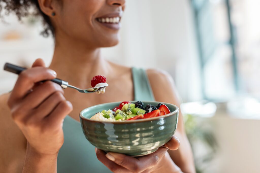 Woman enjoying fruit salad.