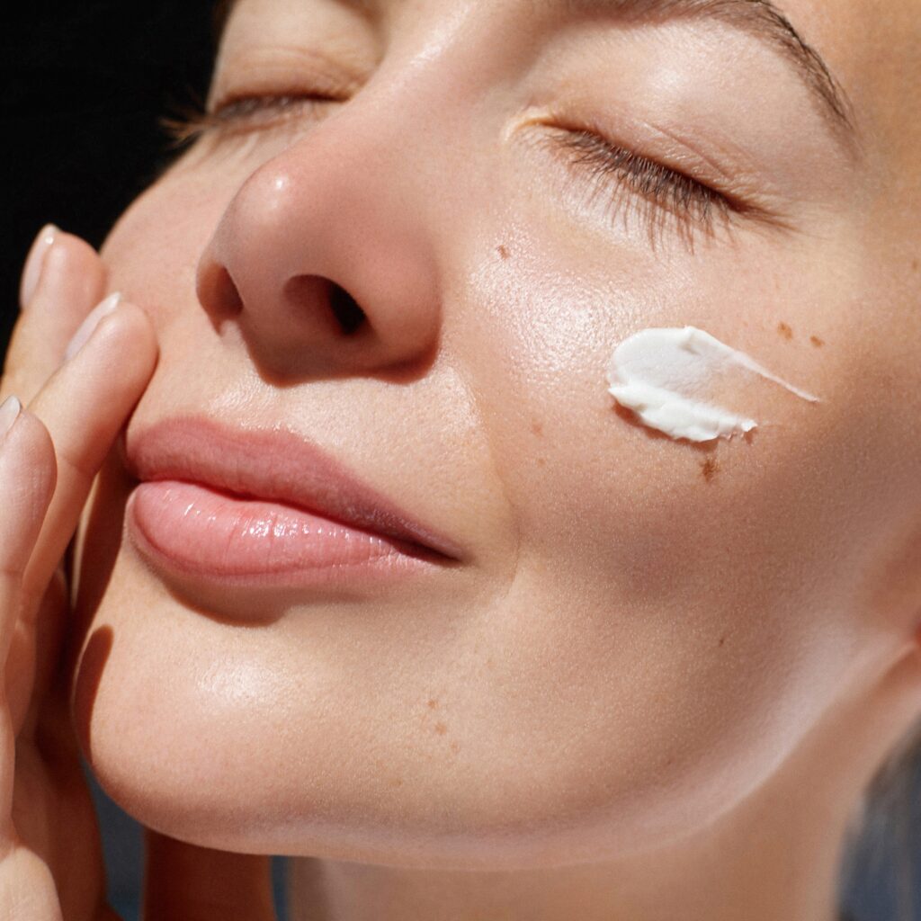 Woman applying skin care to face