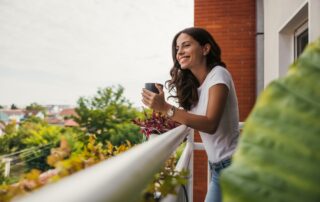 A woman enjoying her morning coffee on a balcony.