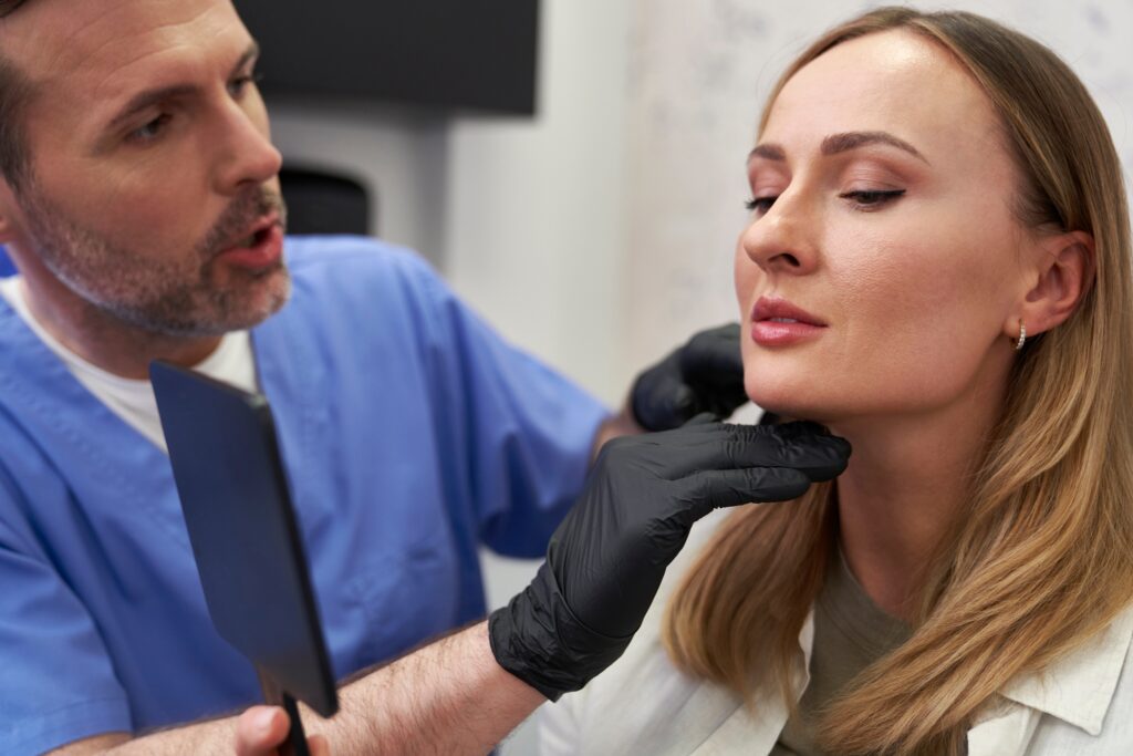 Woman with medical injector who is examing her face prior to a facelift or injection.