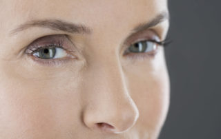 A middle aged woman looking into the camera, as the camera focuses on her eyes.