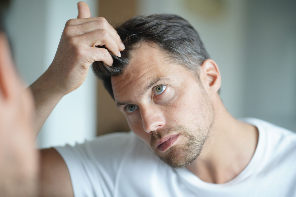 man looking at hair after hair loss treatments