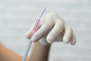 A gloved hand holding a PDO thread