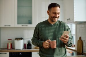 A man smiling at his phone.